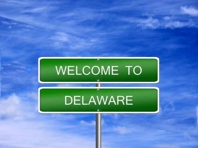 a green street sign that reads "welcome to delaware"