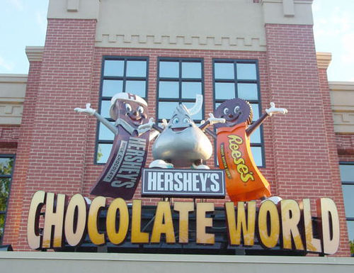 the entrance to chocolate world in hershey pennsylvania, featuring a hershey bar, a hershey's kiss, and a reese's peanut butter cup