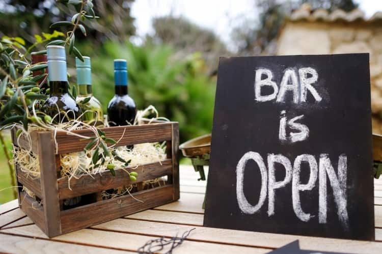 A crate of wine bottles and a sign at a vineyard wedding