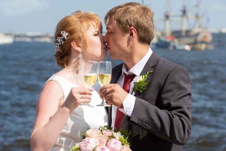 A couple is kissing after a champagne toast