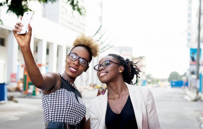 Two women taking selfie in city street