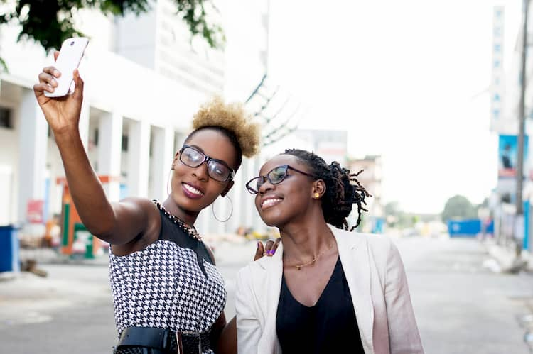 Two women taking selfie in city street