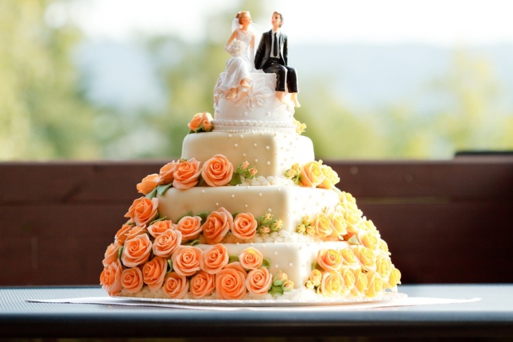 A white wedding cake with an intricate floral design