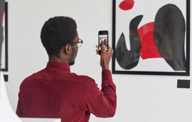 Man taking photo of art in gallery