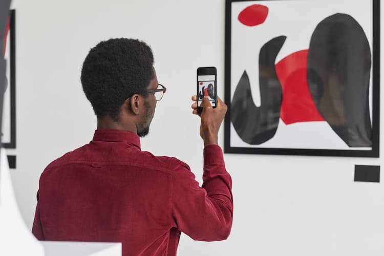 Man taking photo of art in gallery