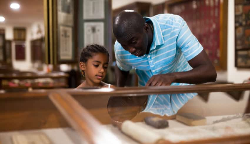 A father and child looking at exhibits in a museum