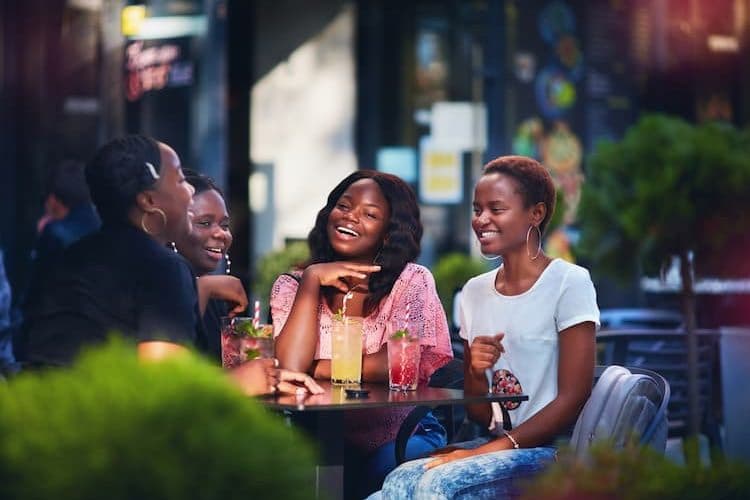 Women having cocktails at table outside