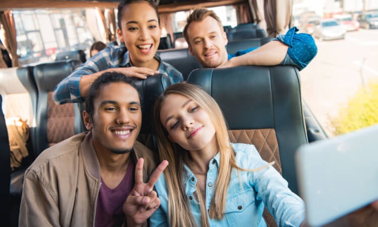 a group of friends taking a selfie on a charter bus